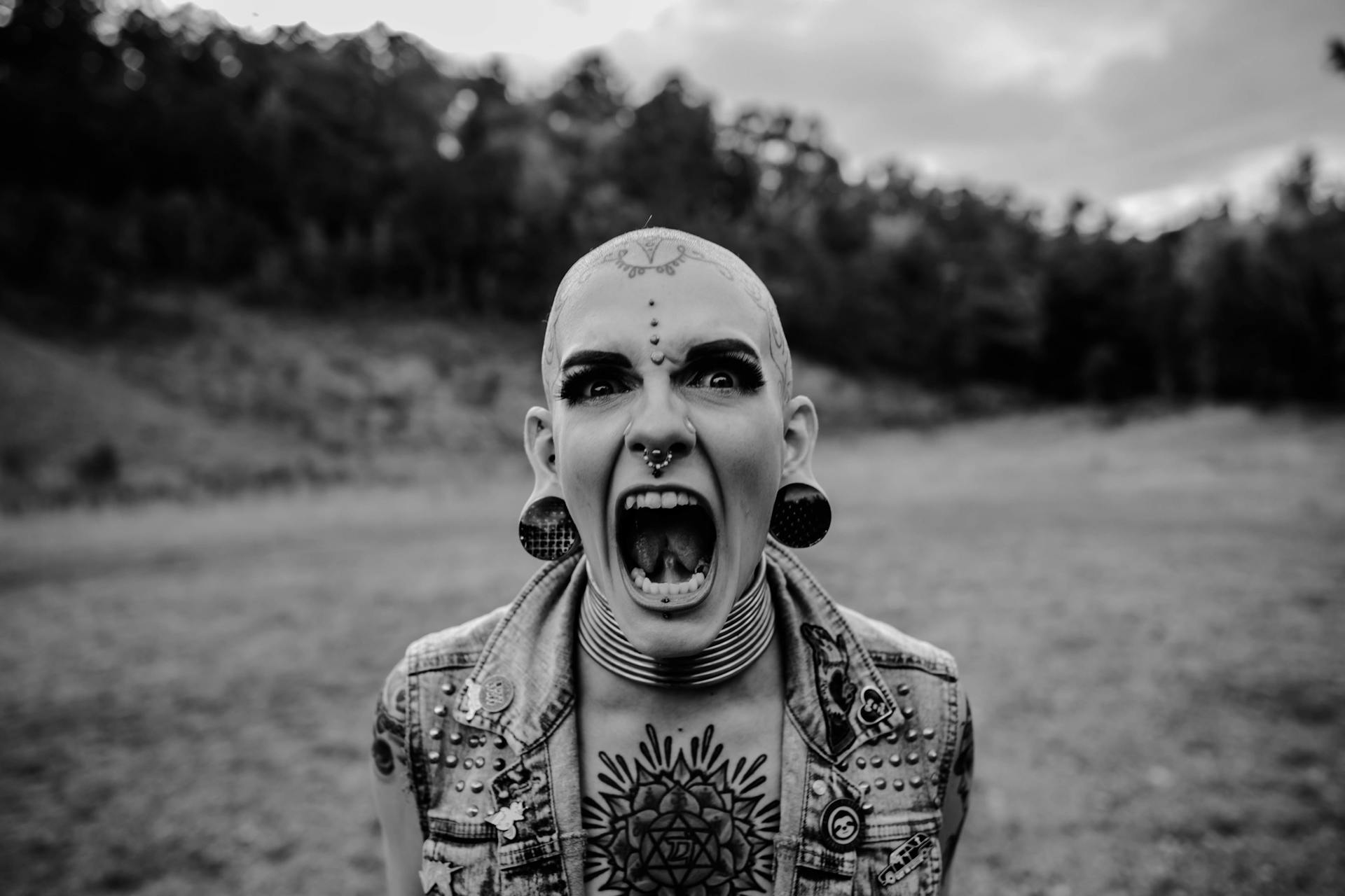 A bald woman with tattoos screaming in anger
